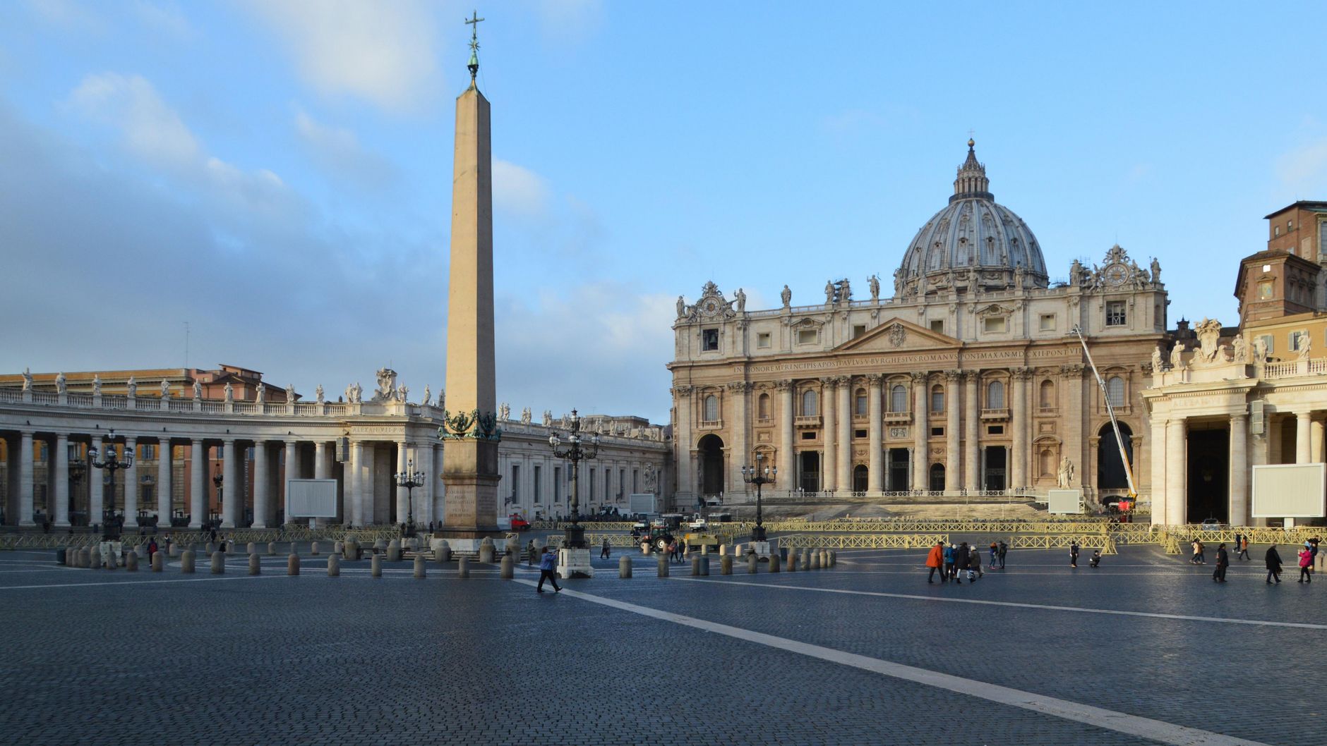 Vatican City view featuring St. Peter's Basilica, obelisk, and colonnades on a sunny day.